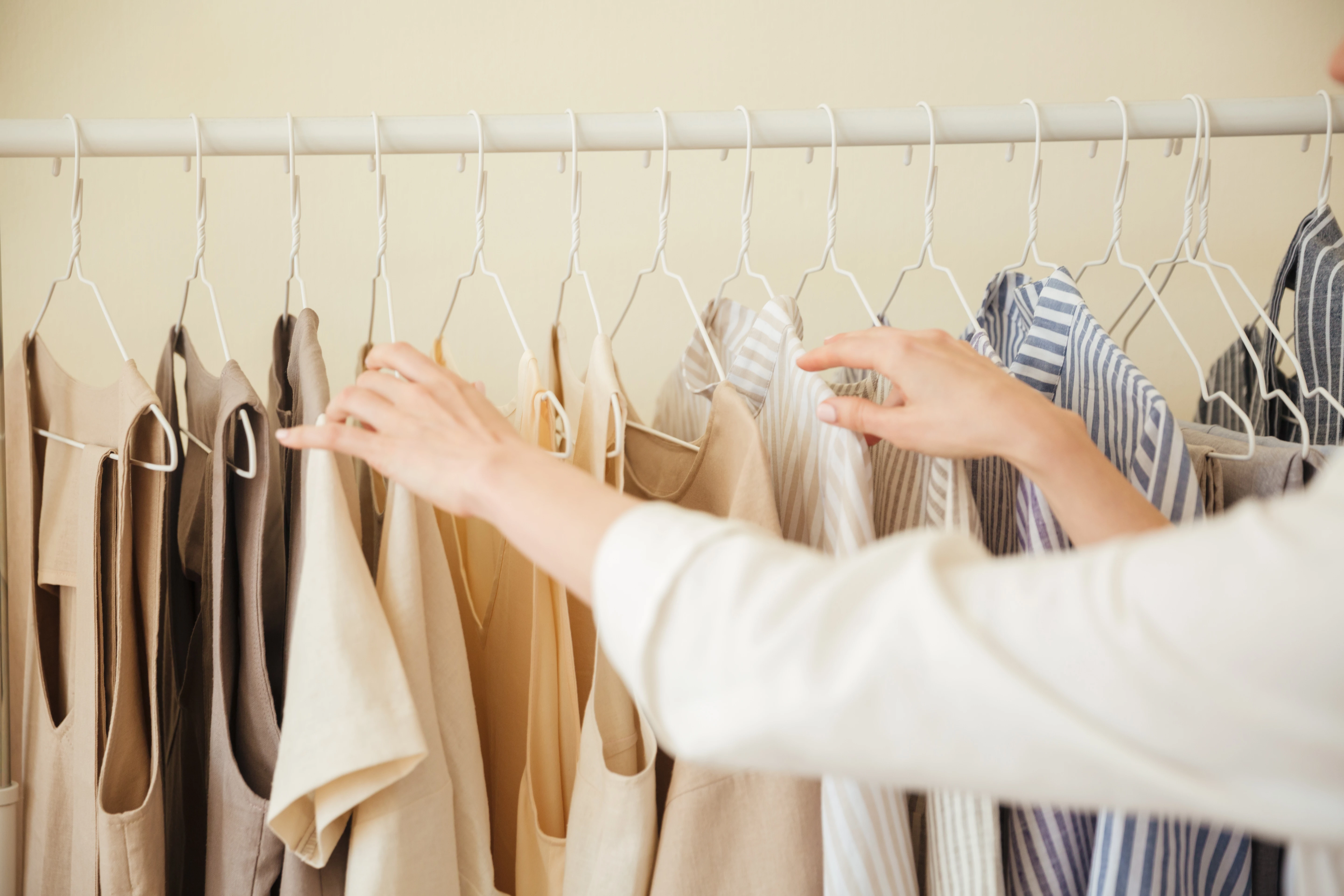 ラックに掛かっている洋服を選んでいる様子