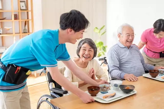 介護施設で食事の給仕を受ける入居者の様子