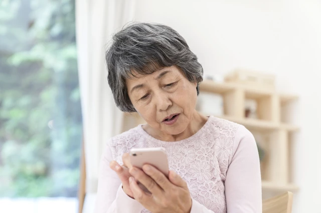 スマホを見つめるシニア女性