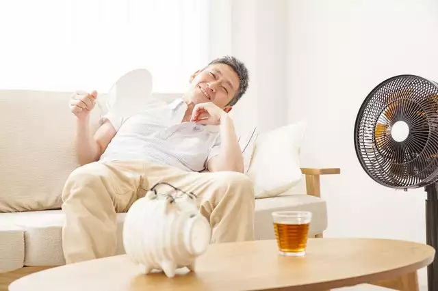 クーラーで涼む男性