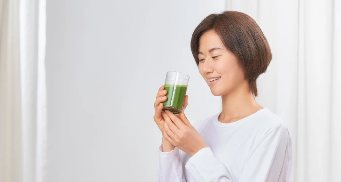 フレッシュな青汁を飲もうとする女性